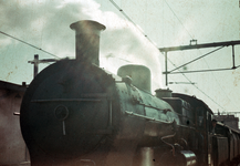 832814 Afbeelding van een trein getrokken door een stoomlocomotief uit de serie 3700/3800 van de N.S. te Gouda.